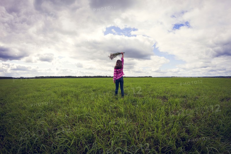 Caucasian girl playing in grassy field