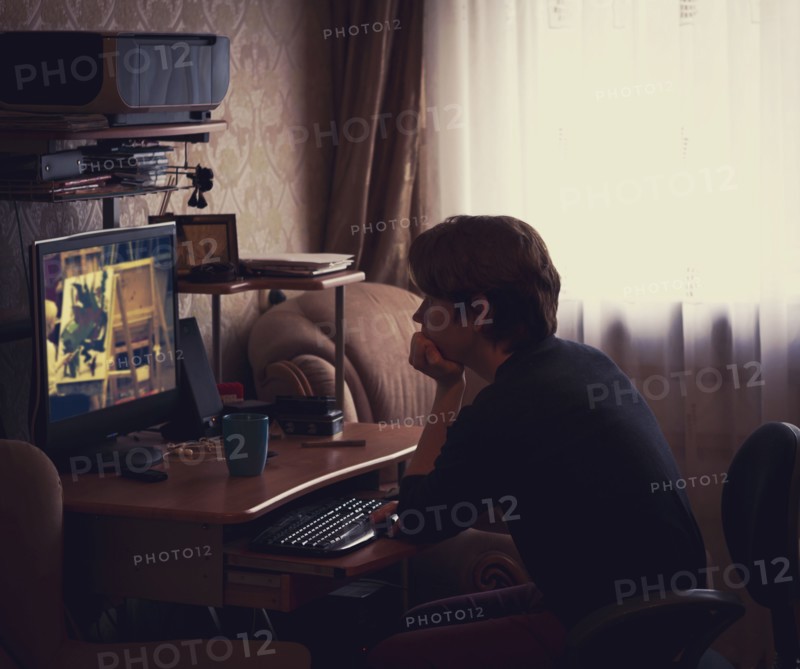 Caucasian man watching computer screen at desk