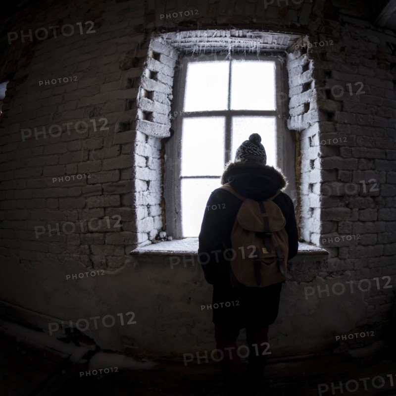 Caucasian man peeping through illuminated window at night