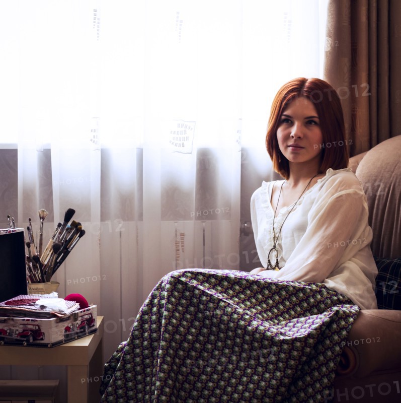 Caucasian woman sitting in armchair near window