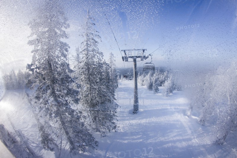 Chair lift gondolas over snowy slopes