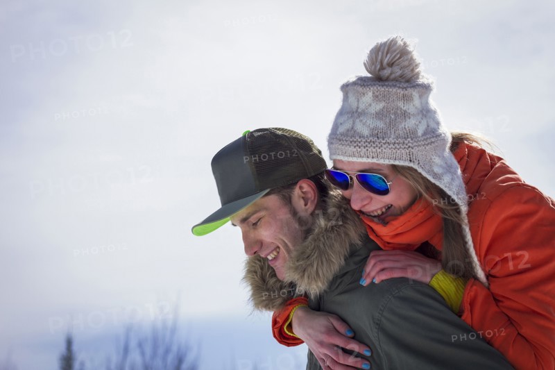 Caucasian man carrying girlfriend piggyback