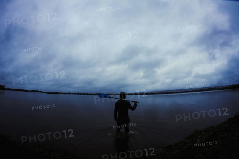 Caucasian man standing in still remote lake