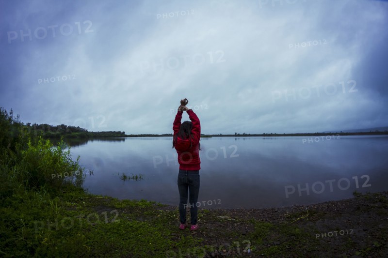 Caucasian teenage girl stretching by remote lake
