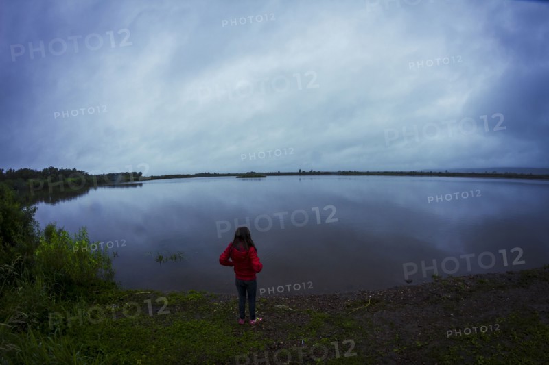 Caucasian teenage girl standing by remote lake