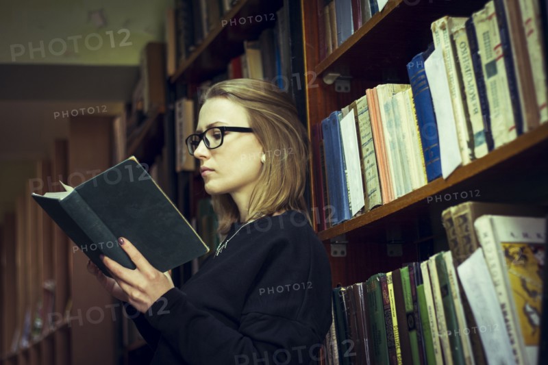 Caucasian woman reading book in library