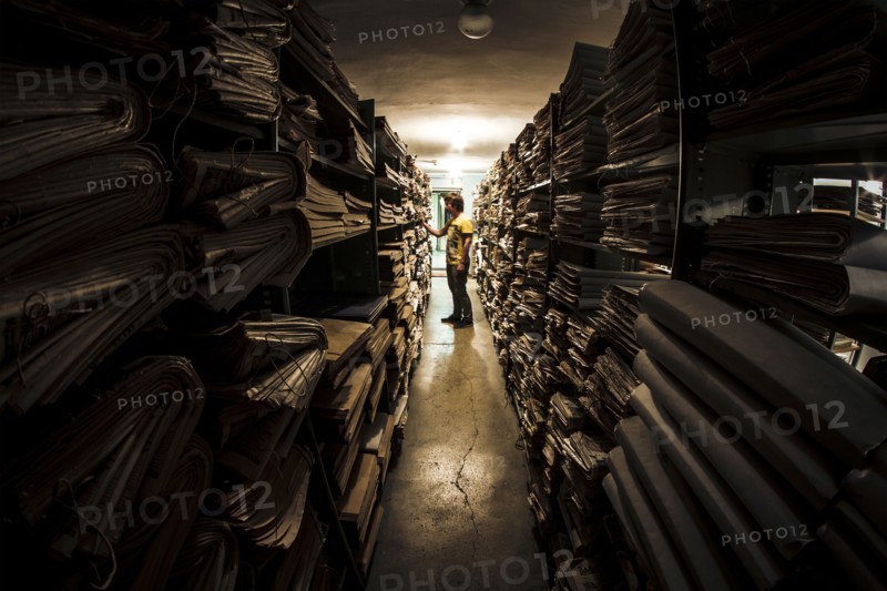 Caucasian man searching old newspapers in library archive