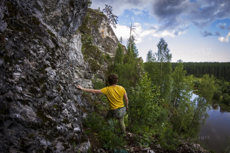 Caucasian man climbing sheer rock cliff