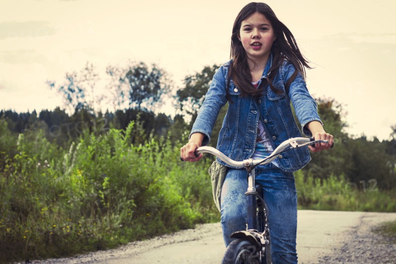 Caucasian teenage girl riding bicycle