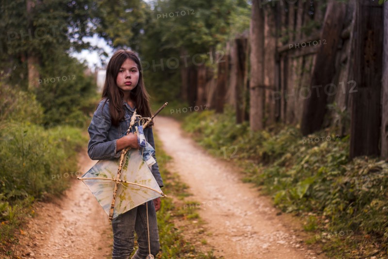 Caucasian teenage girl carrying kite on dirt road