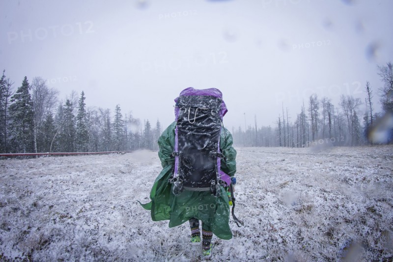 Caucasian hiker standing in frosty field