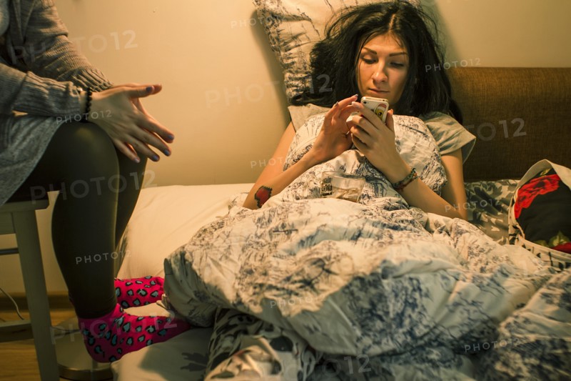 Caucasian woman using cell phone on bed