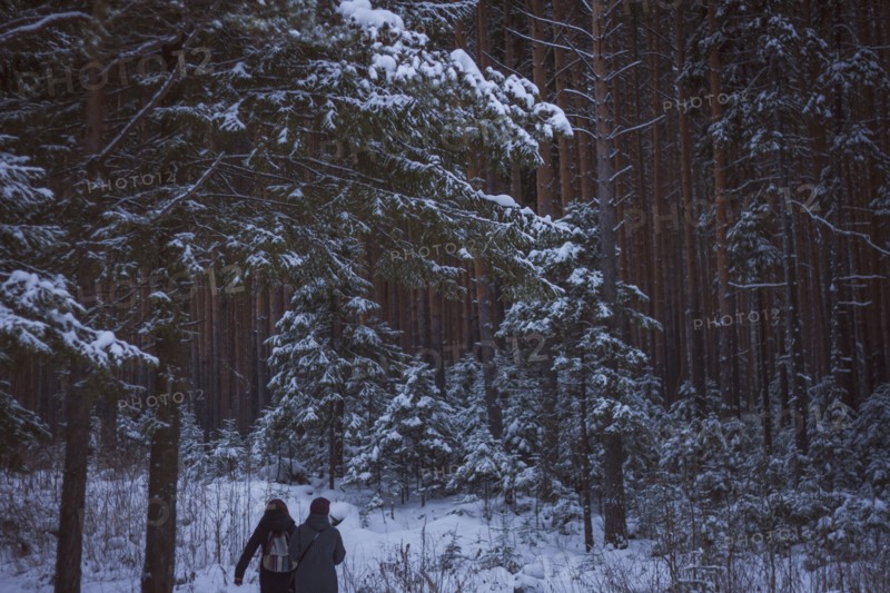 Caucasian women walking in snowy forest
