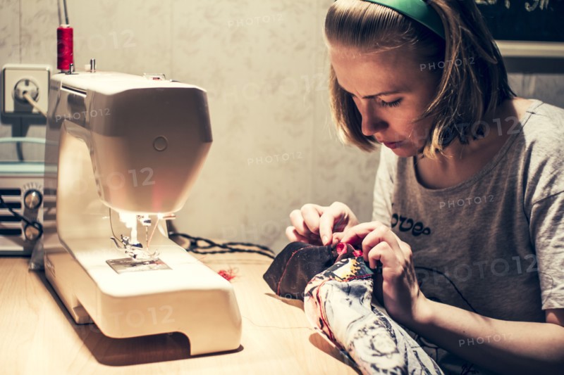 Caucasian woman using sewing machine