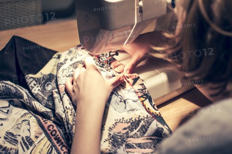 Caucasian woman using sewing machine