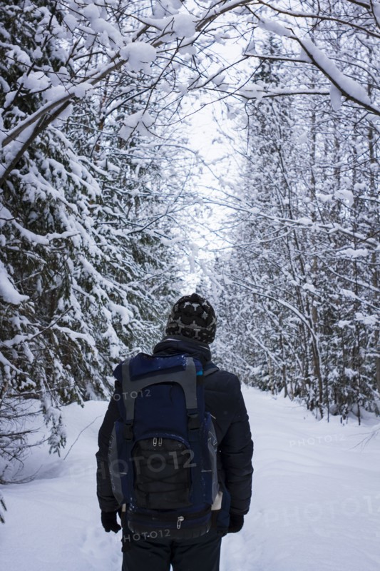 Caucasian hiker standing in snowy forest