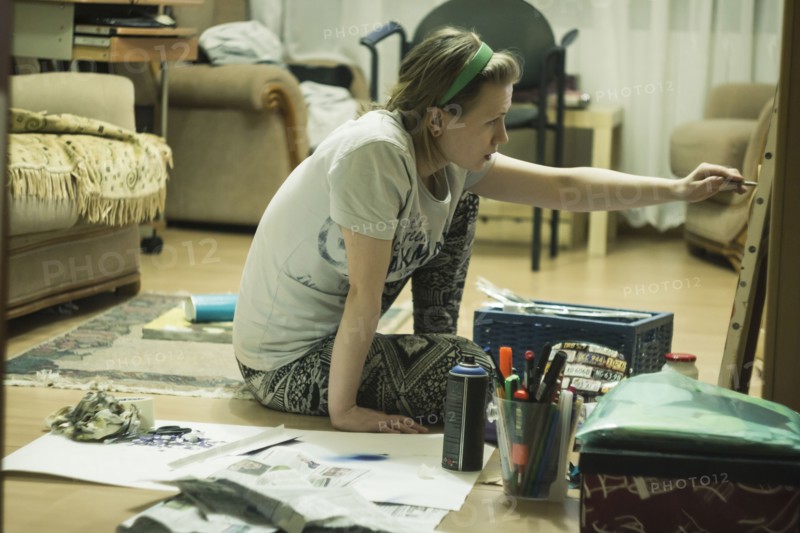 Caucasian artist on painting in living room