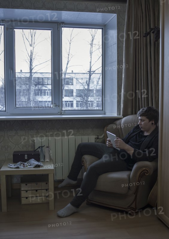 Caucasian man reading digital tablet in living room