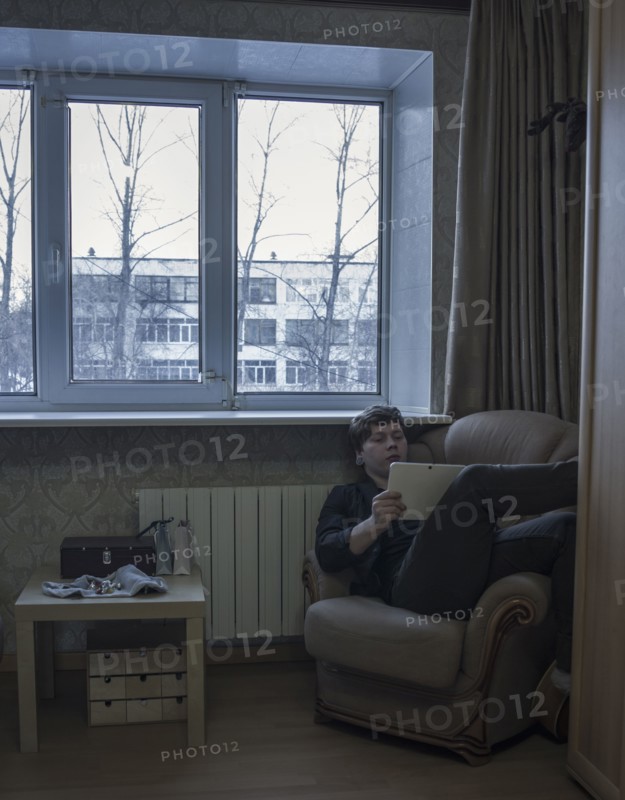 Caucasian man reading digital tablet in living room
