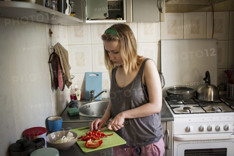 Caucasian woman cutting red peppers in kitchen