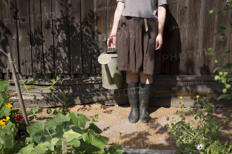 Caucasian woman holding watering can in garden