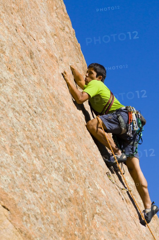 Hispanic man rock climbing