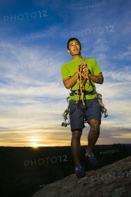 Hispanic man preparing for rock climbing