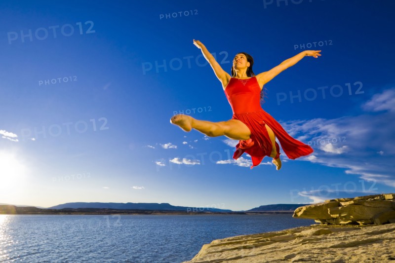 Hispanic woman dancing near lake