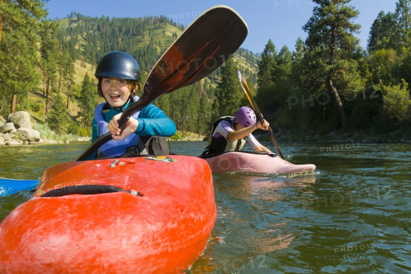 Caucasian girls kayaking in river