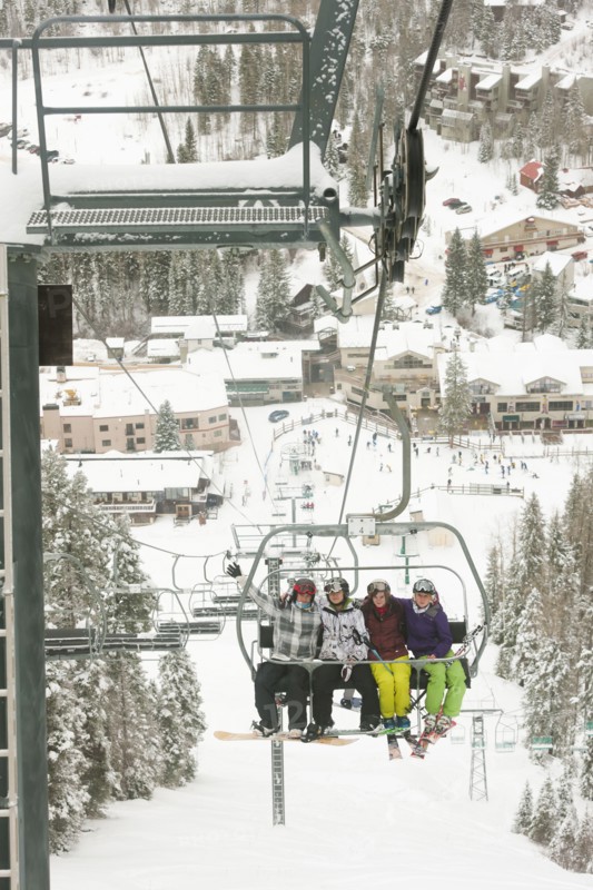 Friends riding ski lift