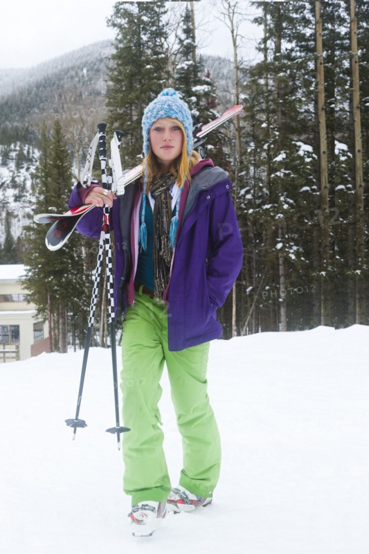 Skier carrying skis and ski poles