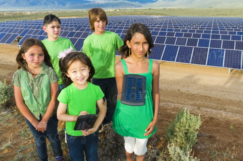 Children standing together in solar panel field