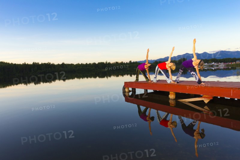 Woman exercising on lake pier