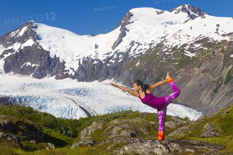 Korean woman practicing yoga with mountain in background
