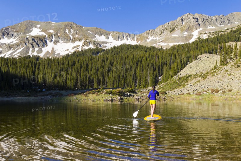 Hispanic woman riding paddle board