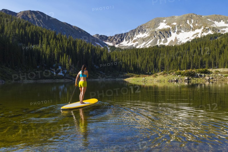 Hispanic woman riding paddle board