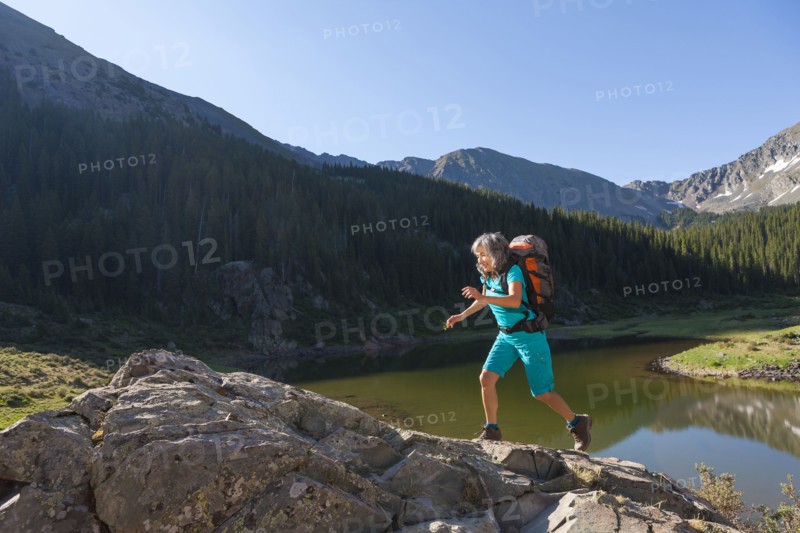 Hispanic woman hiking on boulder