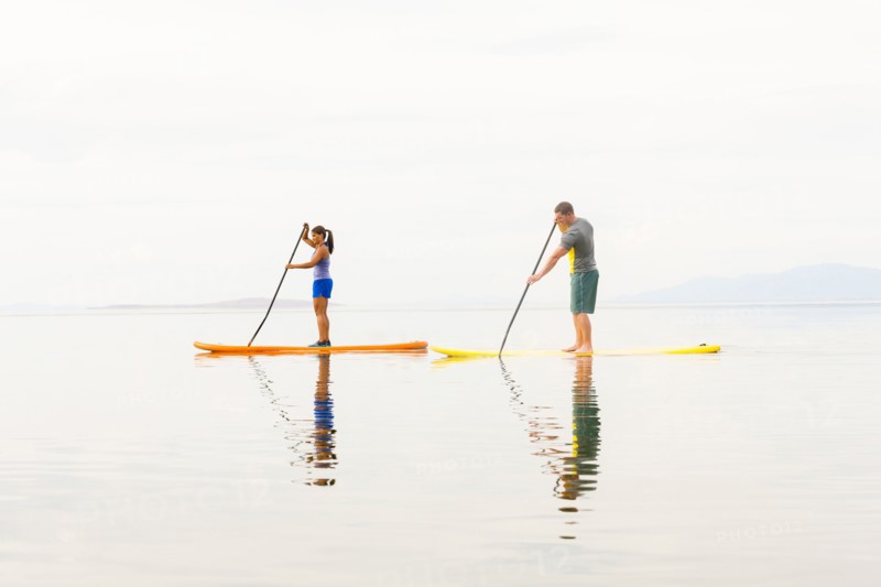 Couple riding paddle boards