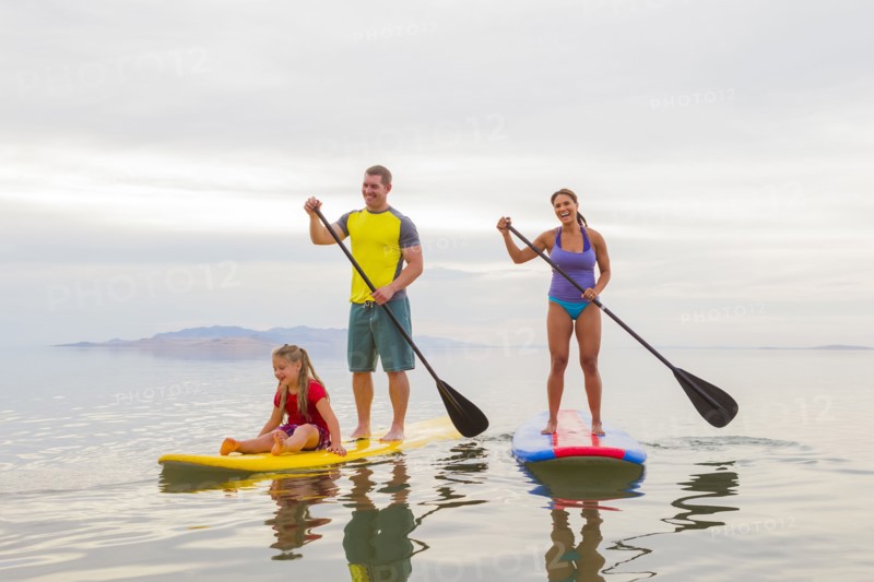 Family riding paddle boards