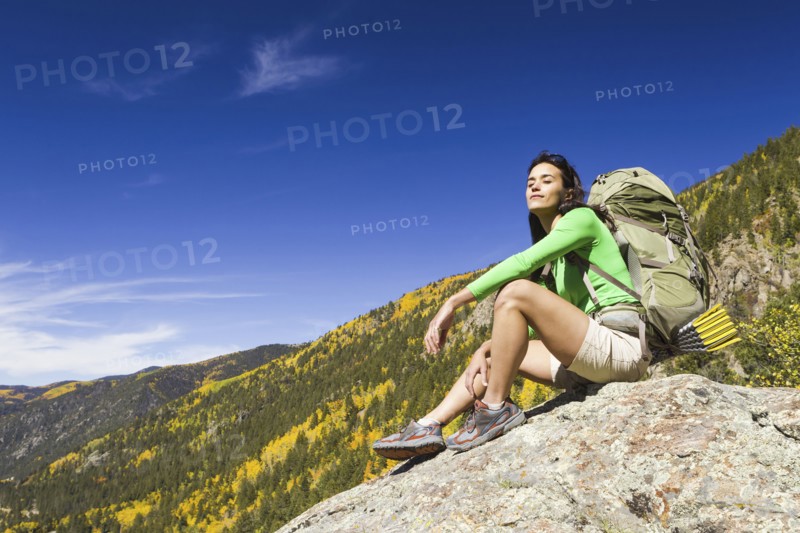 Mixed race woman sitting on rock