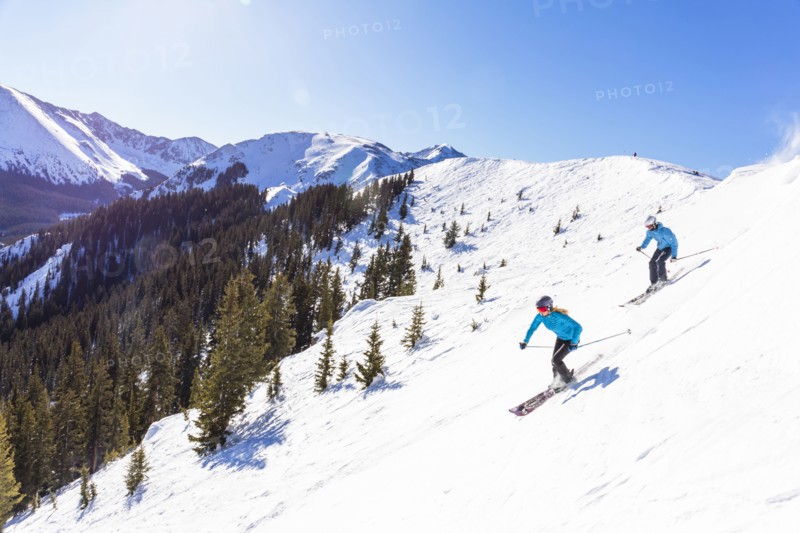Couple skiing on snowy mountain slope