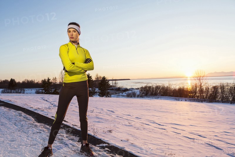 Caucasian runner posing with arms crossed in winter
