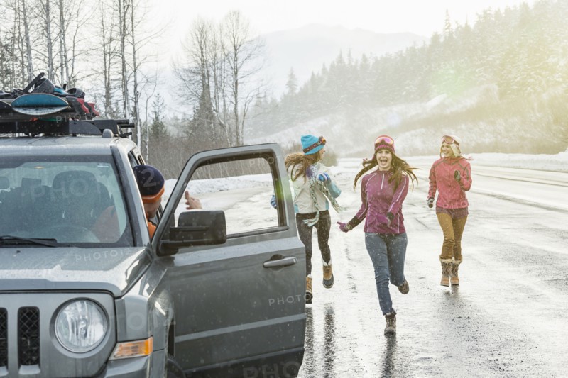 Women running to car in winter