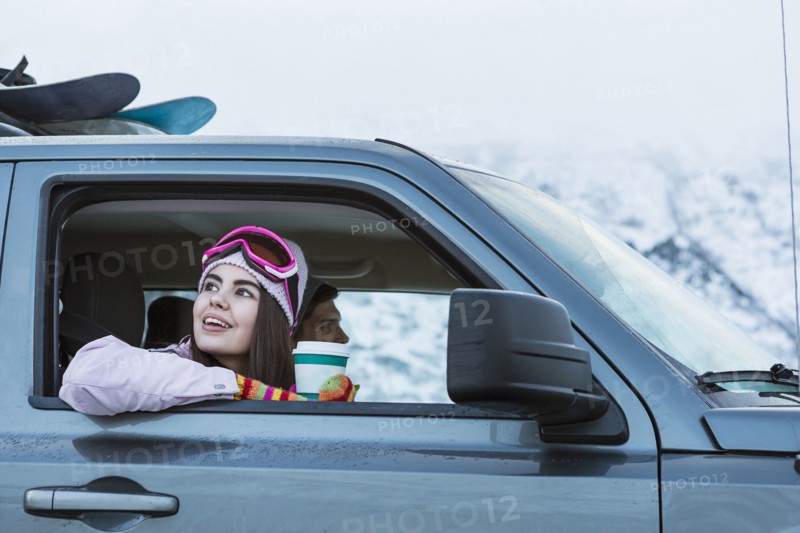 Mixed Race woman leaning on car window in winter