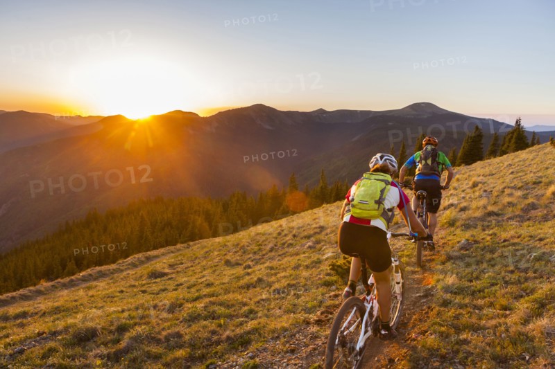 Caucasian couple mountain biking on trail