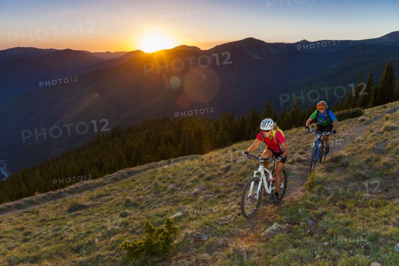 Caucasian couple mountain biking on trail