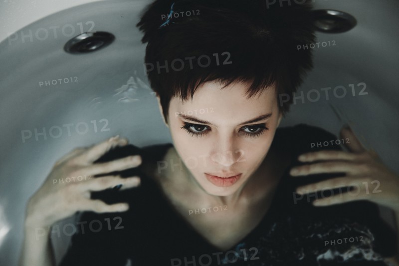 Caucasian woman wearing dress in bathtub
