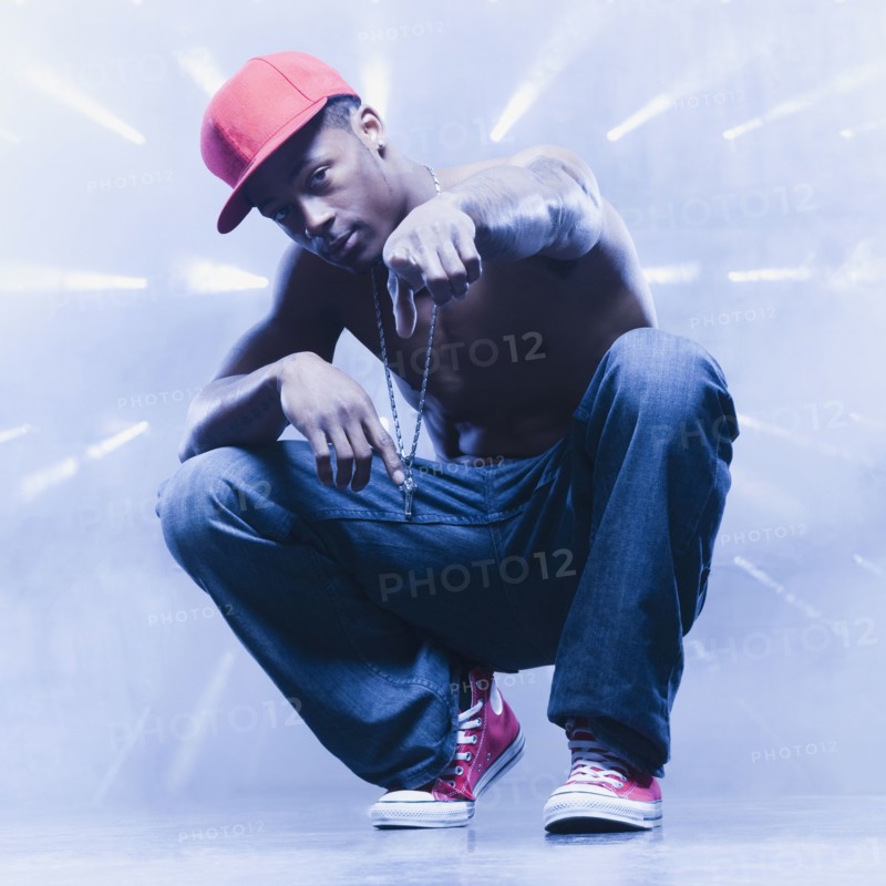 Back lit African man squatting and pointing
