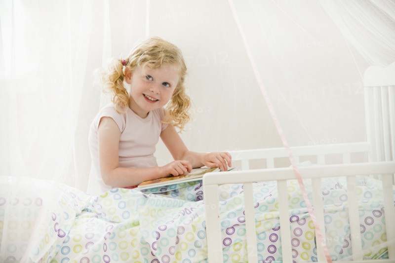 Caucasian girl reading in bed