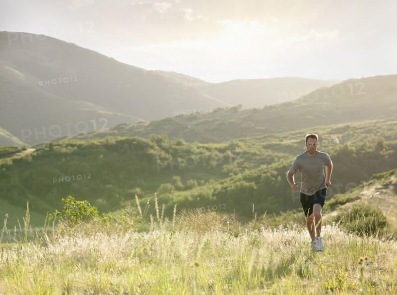 Caucasian man running on remote hill